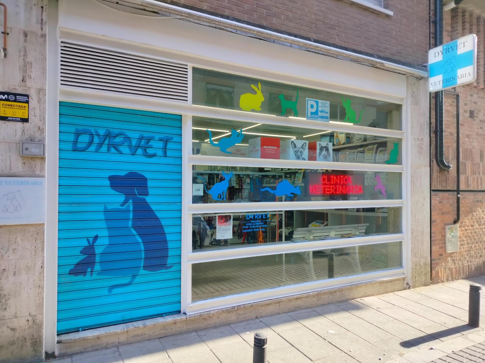 Fachada de Dyrvet en Aravaca, con la persiana azul pintada y el rótulo de clínica veterinaria